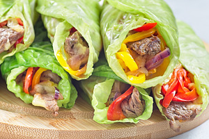 Cabbage leaves wraps with beef, vegetables and cheese, on a round wooden board,, a Food & Drink Photo by iuliia_n