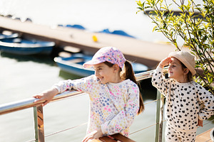 Two girls enjoying a sunny day by the water near a dock, a Person Photo by AS photostudio
