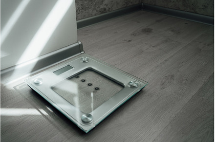 Home floor scales on the grey floor, a Person Photo by Ksenia Neyman