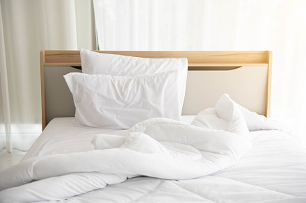 White unmade bed in the morning with sunshine with white curtain, a Person Photo by Ministocker
