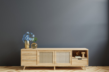 Cabinet for TV in living room on dark blue wall.