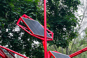 Red pole with solar panels and wind turbine in a green forest environment, a Photo by AS photostudio
