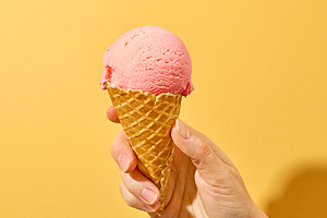 pink ice cream in human hand, a Food & Drink Photo by zeStudioPhoto
