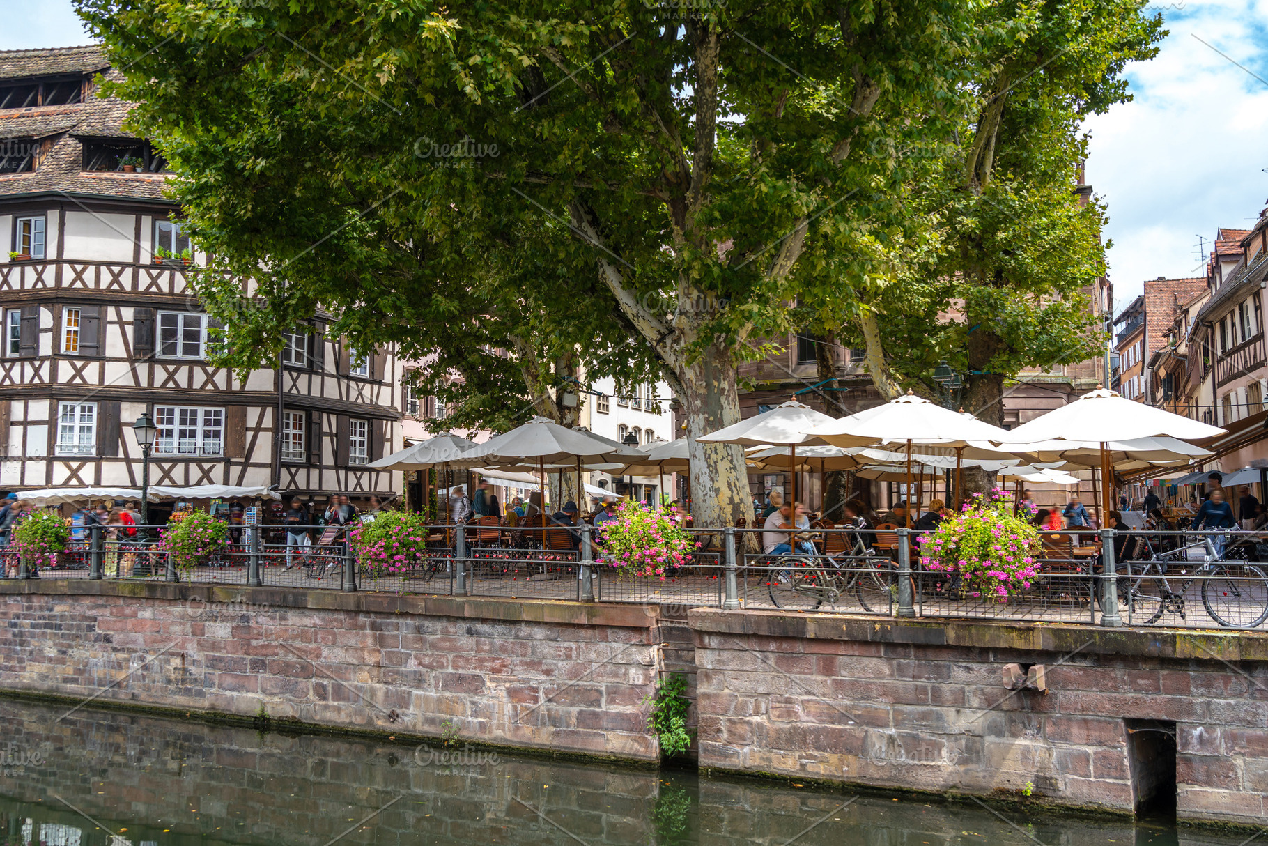 Outdoor café along the canal in Strasbourg France, an Architecture Photo by GoodGoods