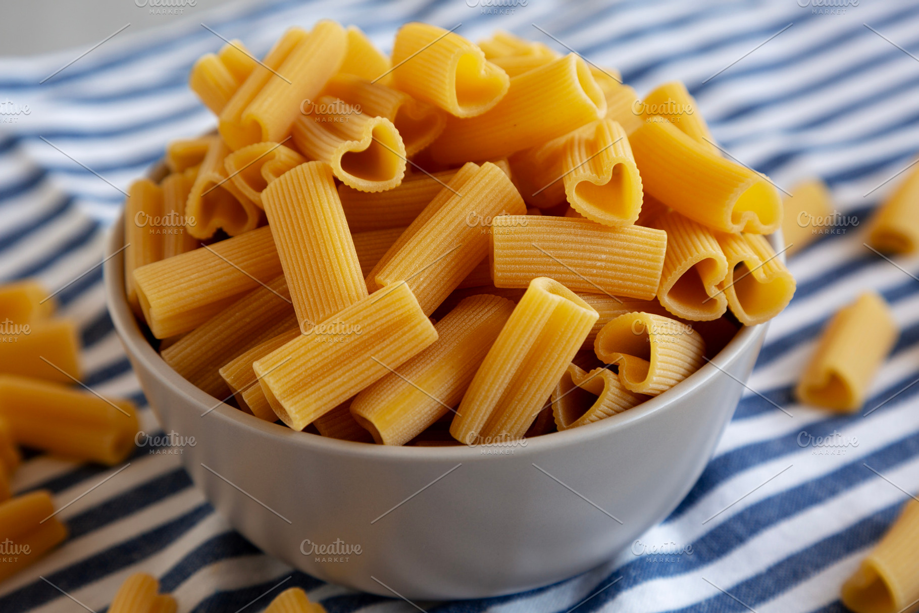 Homemade Raw Heart-Shaped Rigacuore Pasta in a Bowl, side view., a Food & Drink Photo by LiudmylaChuhunova