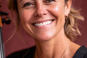 Smiling woman with guitar on red background, a Person Photo by AlyaAnd