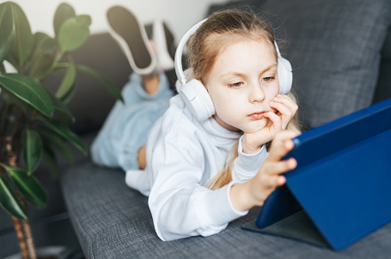 Little girl with headphones and tablet  at home, a School & Education Photo by Olena Rudo