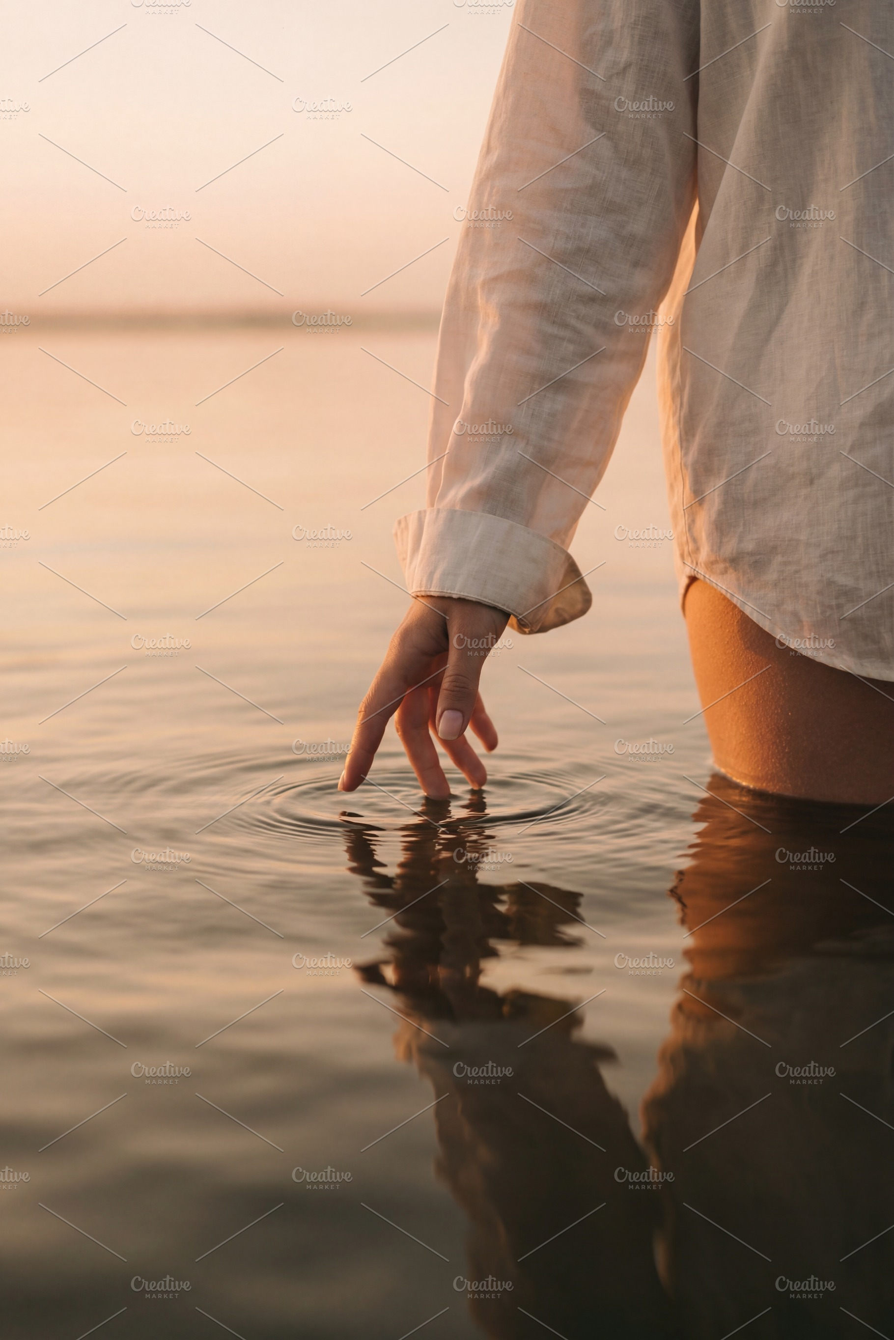 Woman touching calm lake water, a Beauty & Fashion Photo by Virgo Studio