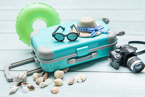 Turquoise suitcase, sunglasses, straw hat, inflatable ring, came, a Holiday Photo by Olena Rudo