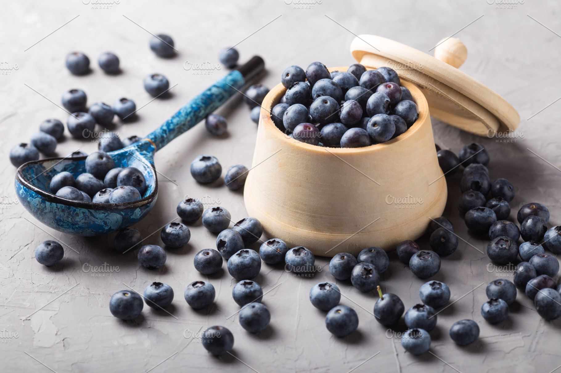 Garden blueberries in a wooden pot and vintage wooden spoon featuring, a Food & Drink Photo by tatyanatitova