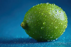 Lime with droplets on blue, a Photo by Beautiful things