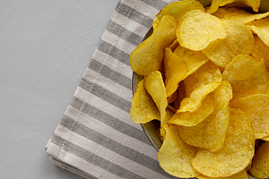 Homemade Kettle Cooked Potato Chips with Salt in a Bowl, top vie, a Food & Drink Photo by LiudmylaChuhunova