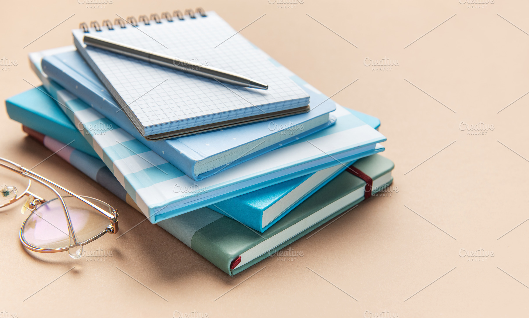 Stack of blue notebooks with pen and glasses, a School & Education Photo by Olena Rudo