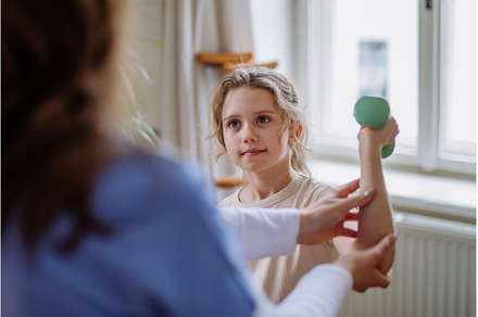 Little girl doing exercise with a, a Health & Medical Photo by HalfPoint