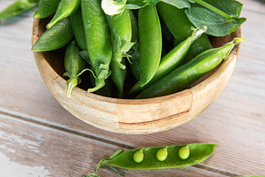 Fresh green pea pods in wooden bowl, a Food & Drink Photo by Olena Rudo