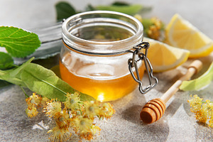 Honey jar with linden flowers and lemon, a Food & Drink Photo by Olena Rudo