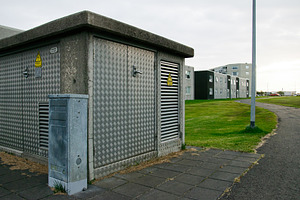 Metal-clad electricity utility building near modern residential housing in Akra, a Photo by AS photostudio
