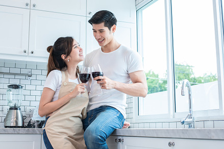 Asian lovers or couples drinking wine in kitchen room at home. L, a Person Photo by Ministocker