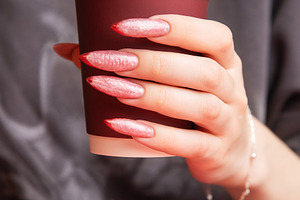 Woman holding paper cup with stylish long nails, a Beauty & Fashion Photo by Olena Rudo