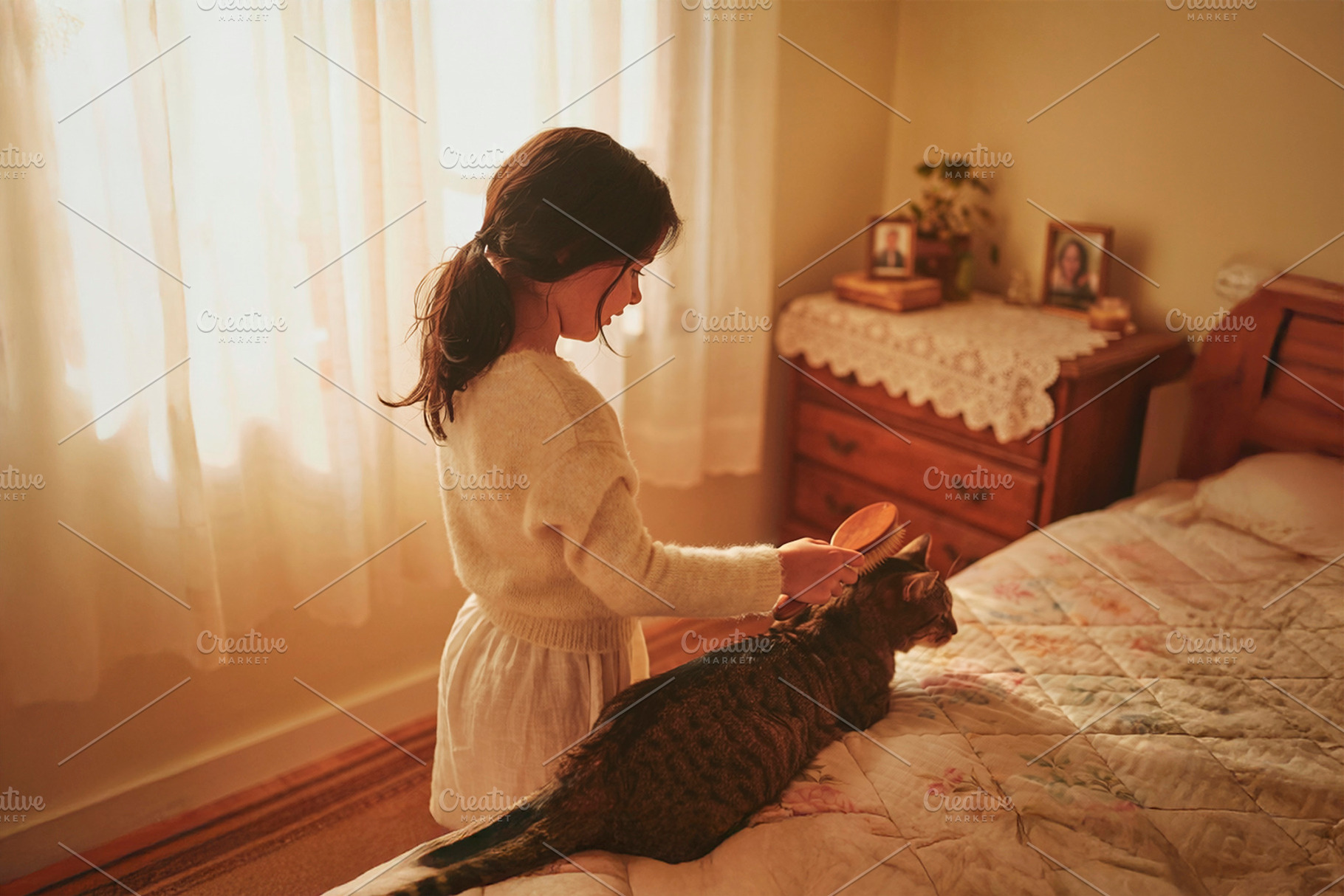 Young girl seen in her bedroom brushing her cat back, a Person Photo by DanFLCreativo