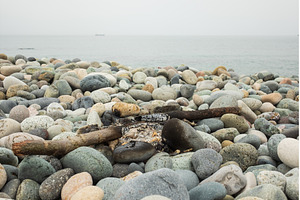 Burnt bonfire on the beach. Rubbish