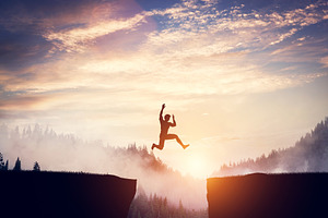 Man jumping between cliffs at sunset, a Person Photo by Photocreo Michal Bednarek