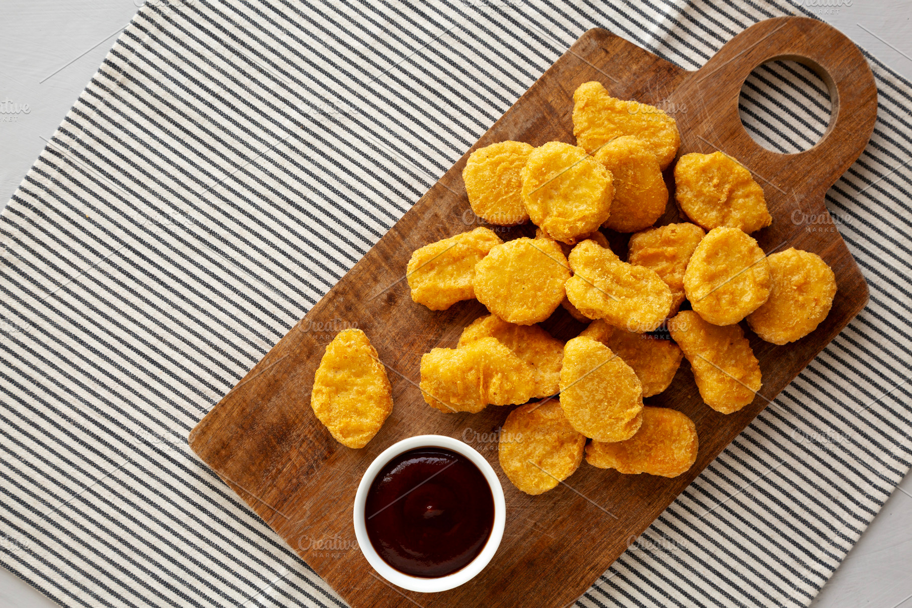 Organic Fried Chicken Nuggets on a wooden board, top view. Copy, a Food & Drink Photo by LiudmylaChuhunova