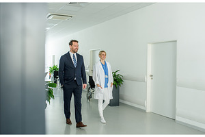 Male hospital manager walking by, a Person Photo by HalfPoint