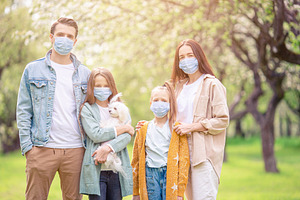 Adorable family in blooming cherry g stock photo containing family and mask