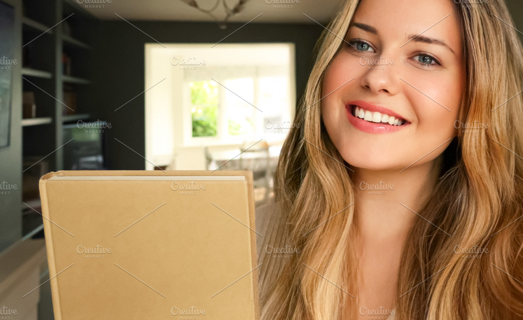 Happy young woman smiling, holding a book, enjoying home life an, a Person Photo by Studio ANNA