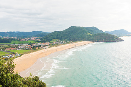 Picturesque view of coastline with green hills, a Holiday Photo by Iván Moreno STOCK PHOTO