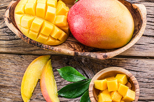 Mango fruit and mango cubes on the wooden table., a Food & Drink Photo by Volff