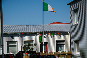 Ireland flag with Irish decorations in Akranes, Iceland under blue skies, a Photo by AS photostudio