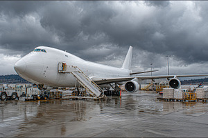 White Cargo Plane Loading Under Stor, a Photo by Pixeness Studio