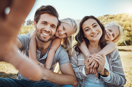 Selfie, park and portrait of children with parents enjoying quality time in nature, weekend and holiday. Family, love and happy girls, mom and dad smile for photo bonding, relax and fun together, a Photo by Peopleimages.com
