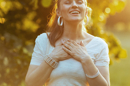 smiling trendy female in white shirt with hand on chest, a Person Photo by Alliance Images