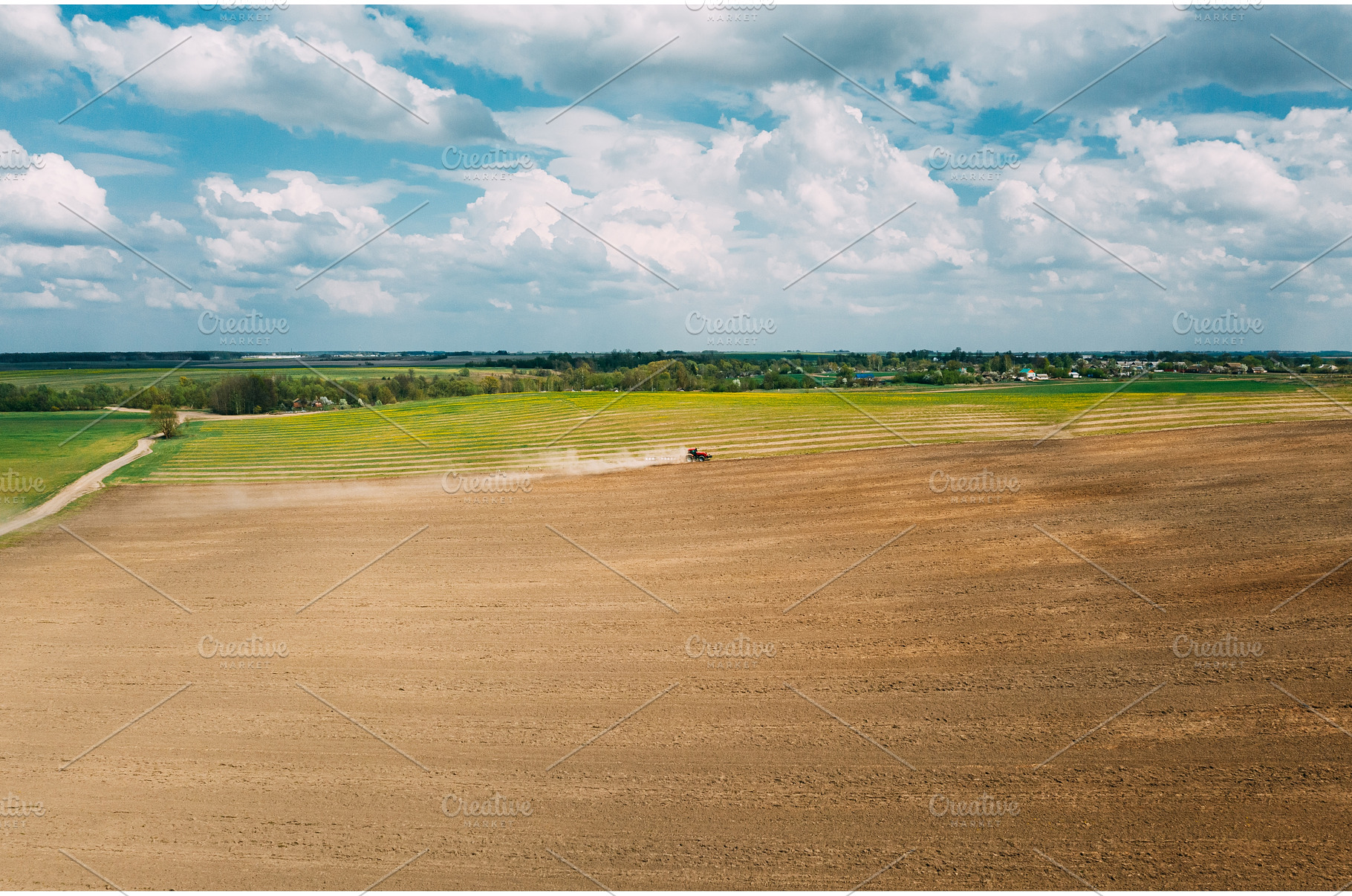 Red Tractor Plowing Field In Spring, an Industrial Photo by Our Amazing World