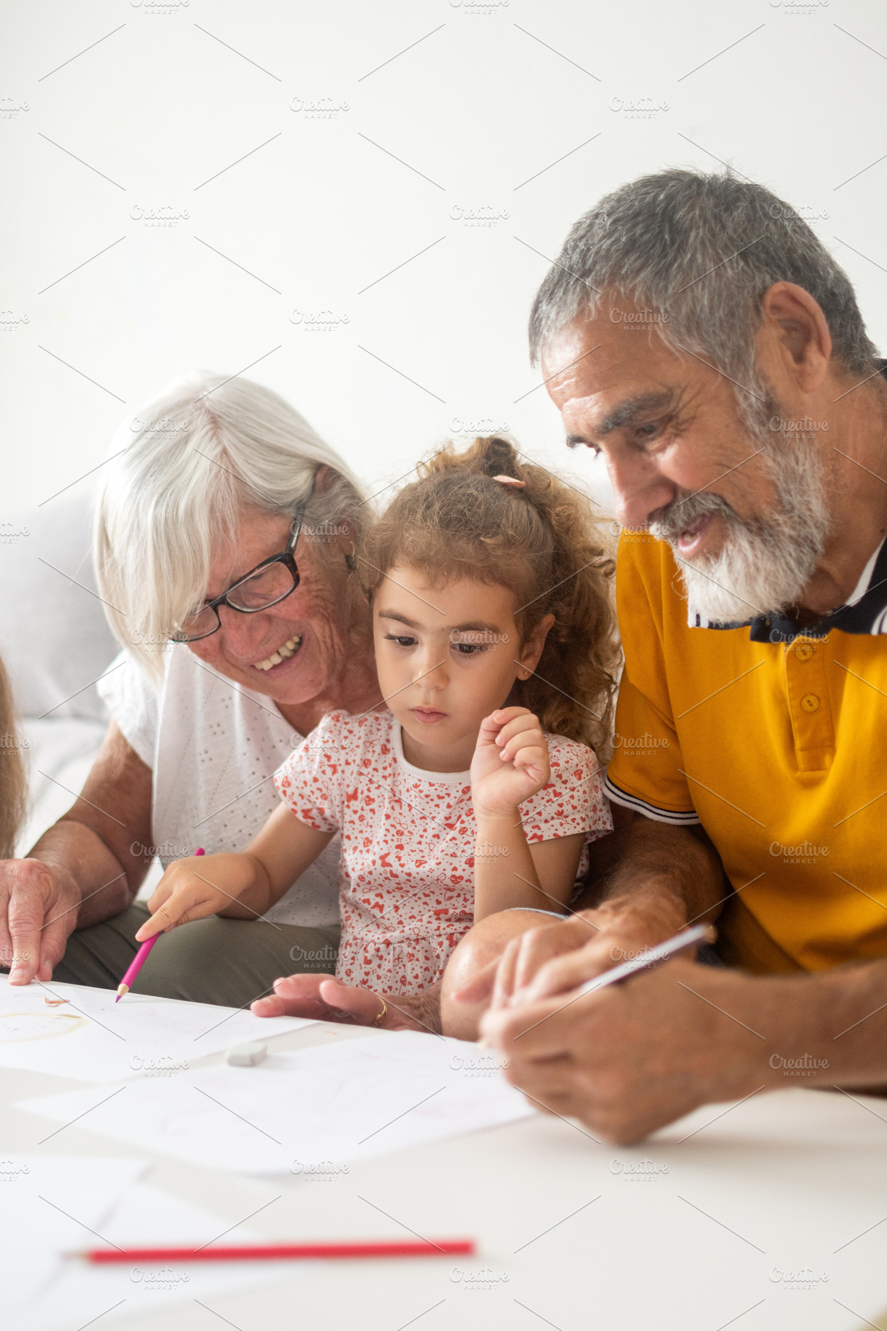 Grandparents helping granddaughters with drawing and homework, a Person Photo by etorres69