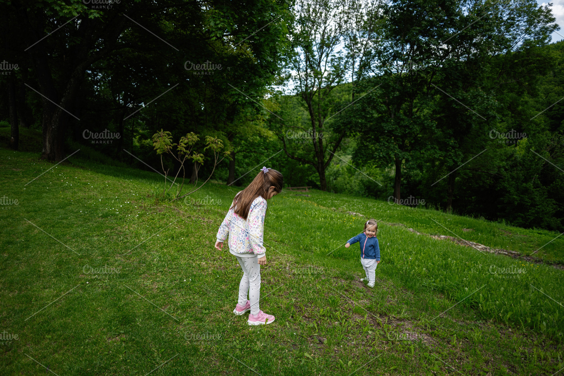 Children enjoying a playful day outdoors in a lush green park, a Photo by AS photostudio
