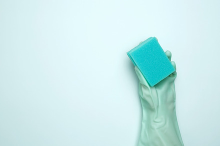 House cleaning. Womans hand in rubber glove holds dishwashing sponge. Copy spac, a Photo by matucha