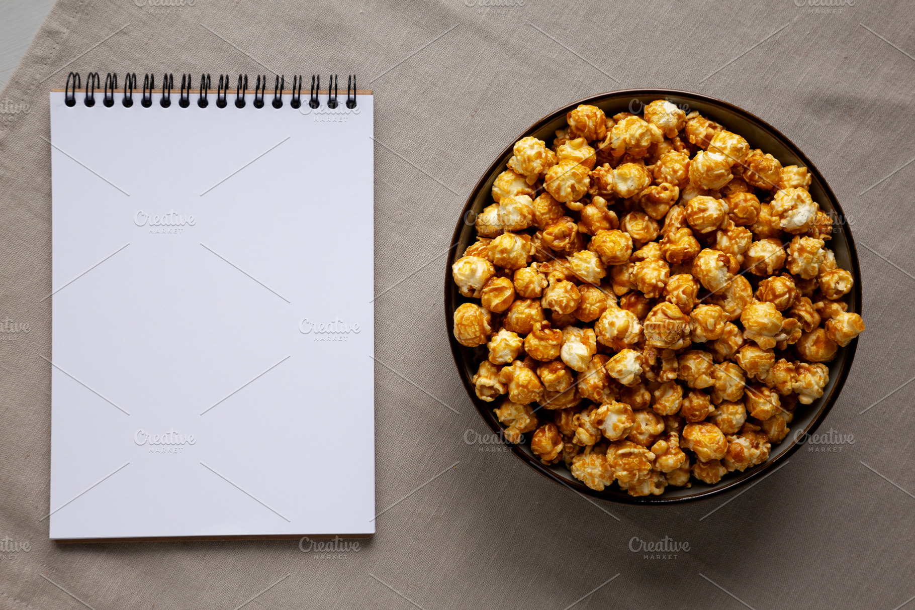Homemade Caramel Pop Corn in a Bowl, blank notepad, top view., a Food & Drink Photo by LiudmylaChuhunova