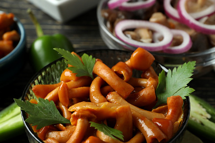 Bowls of marinated mushrooms on rustic wooden table, a Food & Drink Photo by AtlasStudio PRO