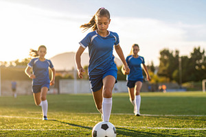 Young girl soccer player dribbling on field, a Sports & Recreation Photo by Davizro's Market