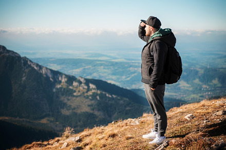 Young man  looking away in front of mountain on sunny day., a Person Photo by Olena Rudo