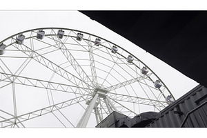 White ferris wheel slowly rotating, an Architecture Photo by Media Whale Stock
