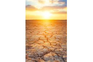 Sunset over cracked desert landscape, a Nature Photo by Lermont51