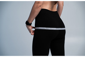 Woman measuring hips, focusing on, a Sports & Recreation Photo by volodymyrshtun13795