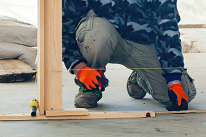 Construction worker measuring and marking guidelines on concrete floor, an Industrial Photo by Antonio Gravante Market