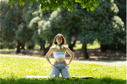 A woman is sitting on the grass in a