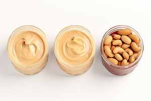 Glass jars of hazelnut, cashew and almonds butter on white background, a Food & Drink Photo by AlyaAnd